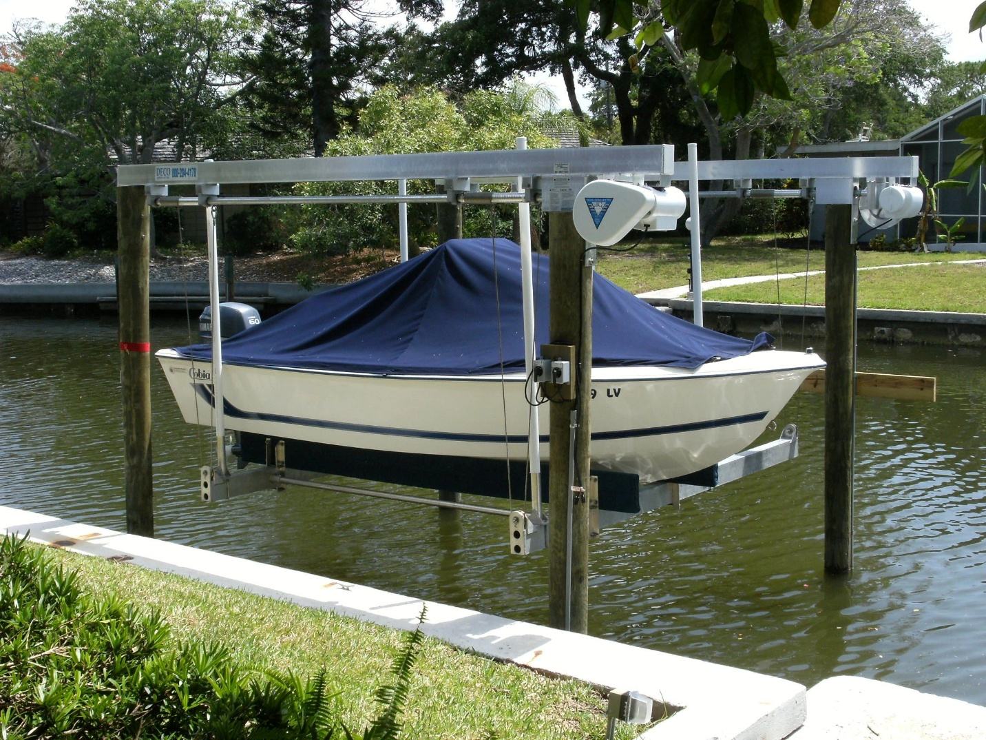 Four post boat lift with a boat raised on a residential canal