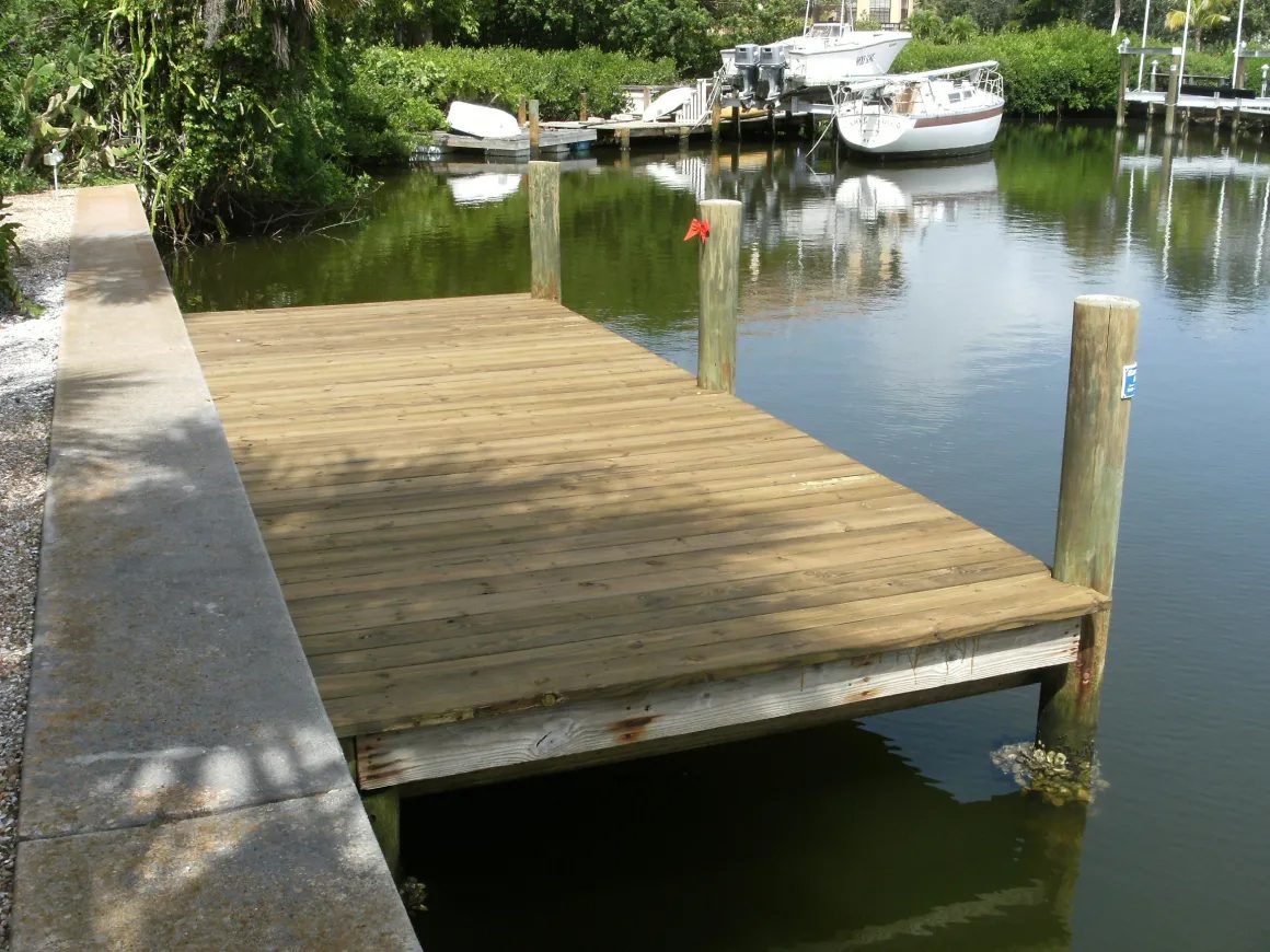 Timber dock platform built off a concrete seawall on a Sarasota County canal