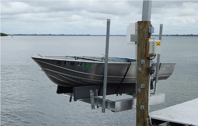 Small aluminum boat on a single post lift